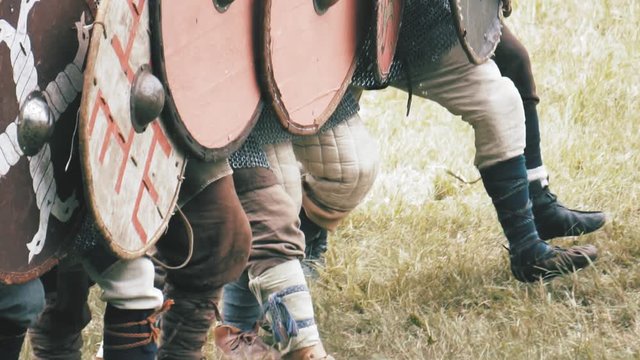 Knight warriors marching forward, shield wall. Medieval soldiers in full armor
