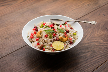 Dapde Pohe is a typical Maharashtrian breakfast, made with thin variety of poha and fresh coconut with chilli, peanuts and nuts. served in a bowl or plate. selective focus