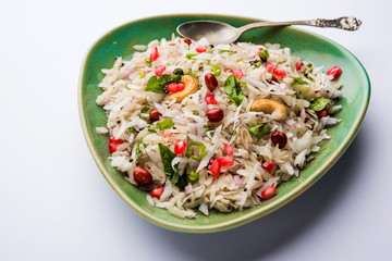 Dapde Pohe is a typical Maharashtrian breakfast, made with thin variety of poha and fresh coconut with chilli, peanuts and nuts. served in a bowl or plate. selective focus