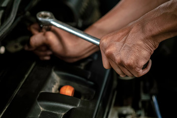 Close up, People are repair a car Use hand a wrench and  screwdriver to work in garage. Safe and confident in driving. Regular inspection of used cars. It is very well done.