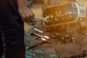 Obraz premium Close up, Service car is People are repair a car Use hand a wrench and a screwdriver to work.Engine repair technicians are hold the wrench in order to repair the car.Image is tone.