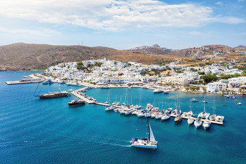 Fototapeta na wymiar Aerial view to Adamas town, the port of Milos island, with blue sea and sailing boats and yachts in the marina, Cyclades, Greece