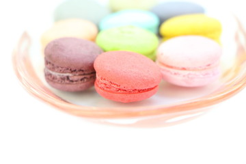 Close up many colorful fresh macarons in red plate isolated on white background, look delicious