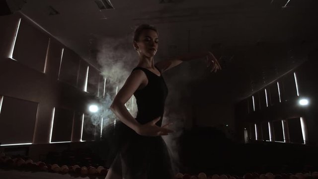 Prima ballerina on pointes training on stage with spotlights in late evening before important performance in Opera and Ballet theatre. Indoors