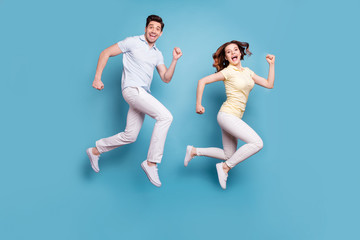 Full length body size view of her she his he nice attractive lovely funny funky cheerful cheery people having fun running isolated over bright vivid shine blue green background