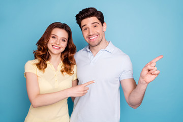 Portrait of his he her she nice attractive cheerful cheery confident people pointing aside ad advert solution isolated over bright vivid shine blue green background