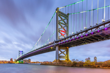 Philadelphia, Pennsylvania, USA skyline on the Delaware river with Ben Franklin Bridge at night.