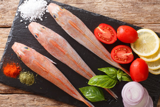 Dietary raw Triglidae, sea robins or gurnard fish with fresh ingredients close-up on a table. horizontal top view