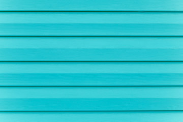 Fototapeta premium Turquoise fence. Plank - timber. Painted blue wooden table in lines. Striped panel, surface, background. Slats texture. Copy space. Abstract bright green pattern of logs.