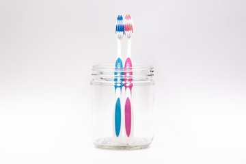 Couple toothbrush in a glass jar isolated in white background