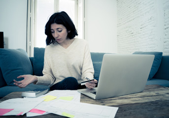 Stressed and overwhelmed young woman trying to manage home finances paying bills feeling desperate