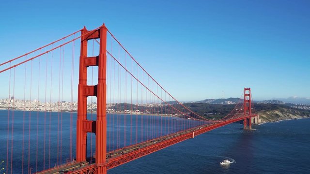 side aerial view of cars driving traffic busy on iron red golden gate bridge in san francisco landscape usa with blue sky ocean sea. famous attraction in united states on summer vacation trip travel
