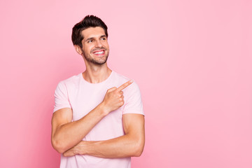 Portrait of his he nice attractive cheerful cheery confident content dreamy guy pointing forefinger aside promotion cool good surprise gift present ad isolated over pink pastel background