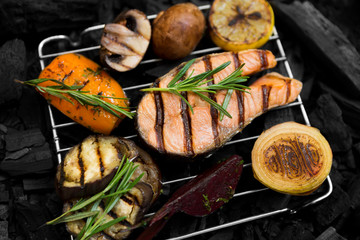 Close up of grilled fish with season vegetables on grate