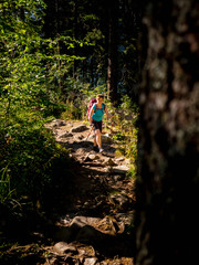 Women hiking through wood and rocks at Lac Blanc, Vosges, France