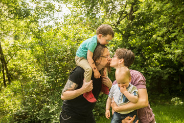 Little boys with parents kissing at the garden