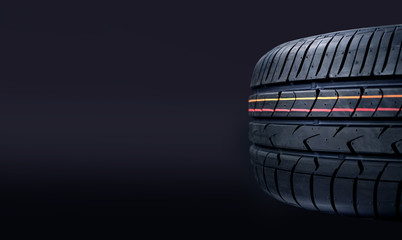 New tire on a dark background. Copy space.