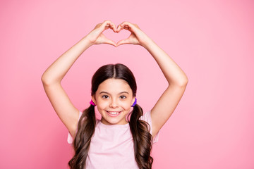 Fototapeta na wymiar Close up photo of cheerful make heart from fingers smiling wearing white t-shirt isolated over pink background