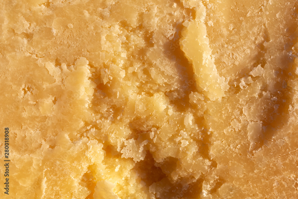 Wall mural italian parmesan cheese. cheese surface close-up. yellow abstract food background