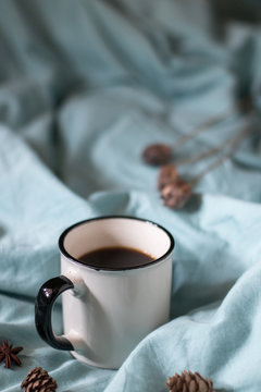 Coffee cup on a bed. Atmospheric hygge style. Good morning still life
