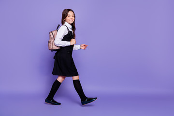 Full length body size profile side view of nice attractive lovely cheerful cheery wavy-haired pre-teen girl going to school class isolated over bright vivid shine violet background