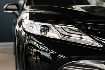 Modern and luxury car headlights. Exterior detail of black car. - Image