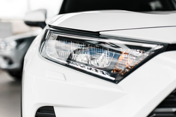 Closeup modern and luxury car headlights. Detail og white automobile