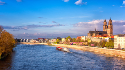 View of Magdeburg with cathedral, river Elbe and cargo boat, beautiful bright morning cityscape...