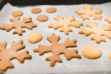 Fototapeta na wymiar Snowflake cookies, baking on the baking sheet. Christmas gingerbread homemade. Merry Christmas card.