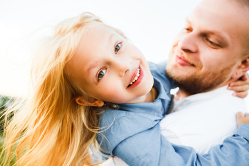 Happy father and child spending time outdoors. Beautiful blonde daughter.