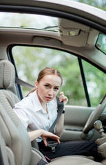 Women's hand fastens the seat belt of the car. Close your car seat belt while sitting inside the car before driving and take a safe journey. Closeup shot of female driver fastens seat belt