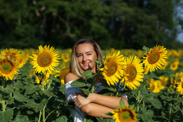 Cute girl in the field full of sunflowers