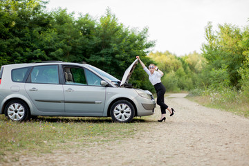 Young woman by the roadside after her car has broken down She opened the hood to see the damage