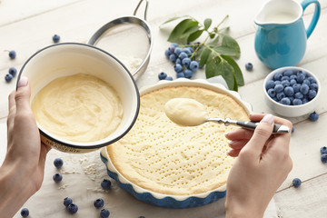Woman pouring whipped cream into pie crust