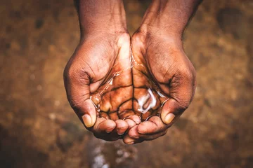 Tuinposter a man holding water with his hand,water crisis in India and worldwide © avijit