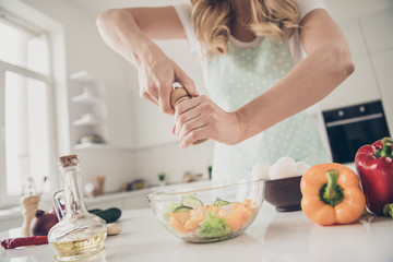 Cropped view of wavy-haired lady making fresh homemade domestic vitamin complex tasty yummy delicious dinner lunch in light white interior kitchen indoors