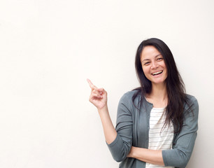 young asian woman pointing finger against white background copy space