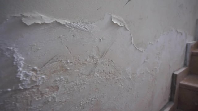 the wall with its paint pouring and swelling due to moisture,