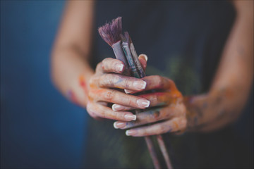  female artist's hands with brushes for painting