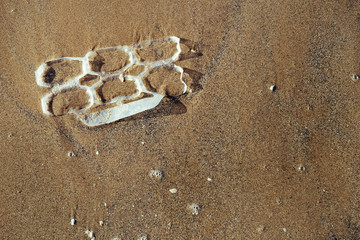 plastic rings polluting the sand of the beach