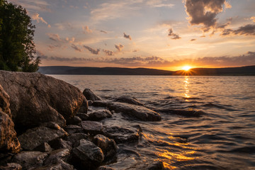 The water at sunset touches the stones	