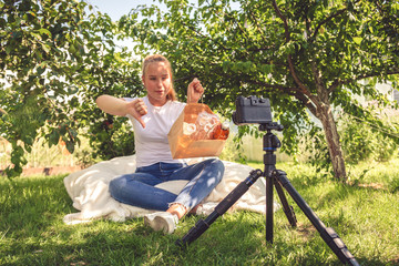 Teen girl shoots a blog on the topic of zero waste and life without plastic in nature in front of...