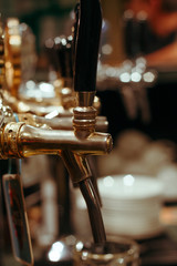 Fototapeta na wymiar Beer Cranes row in the bar selective focus