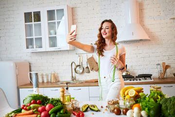 Young beautiful woman take a selfie while cooking in the modern kitchen. Healthy food and Dieting concept. Losing Weight