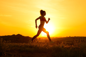 Young Beautiful Woman Running on the Mountain Trail at Hot Summer Sunset. Sport and Active Lifestyle.