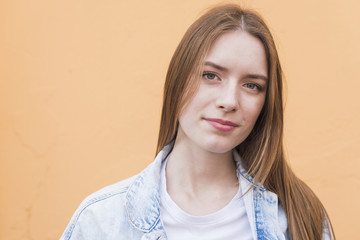 Portrait of young pretty woman against beige background
