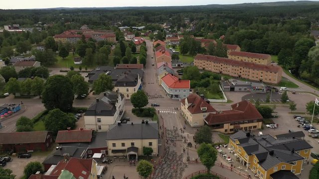 Reverse drone footage revealing the pre start of an MTB race with mountainbikes laying on the street marking the start position. Filmed in realtime.