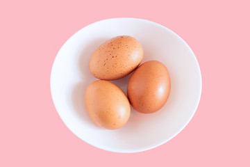 chicken egg, three chicken eggs isolated on white plate background, white plate with chicken eggs on pink background