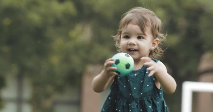 Cute baby girl exploring a park in summer. Real life, candid 4K footage.