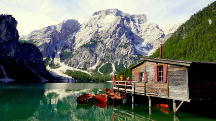 malerischer Blick zum Pragser Wildsee vor steilem Berg in S&uuml;dtirol mit sch&ouml;nem Bootshaus und Ruderbooten 